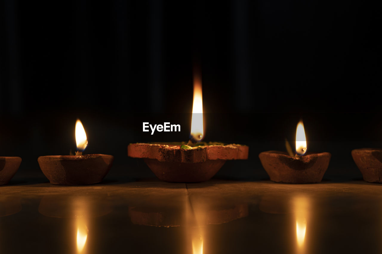 Three diyas kept in a row, celebrating diwali in india.