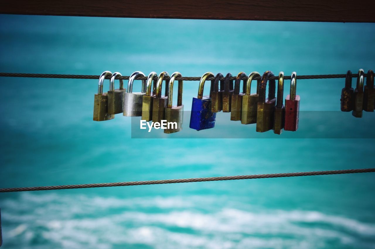 Love padlocks hanging on cable against river