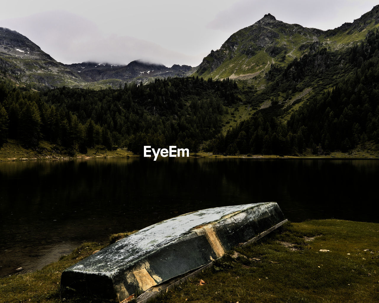 Scenic view of lake by mountains against sky
