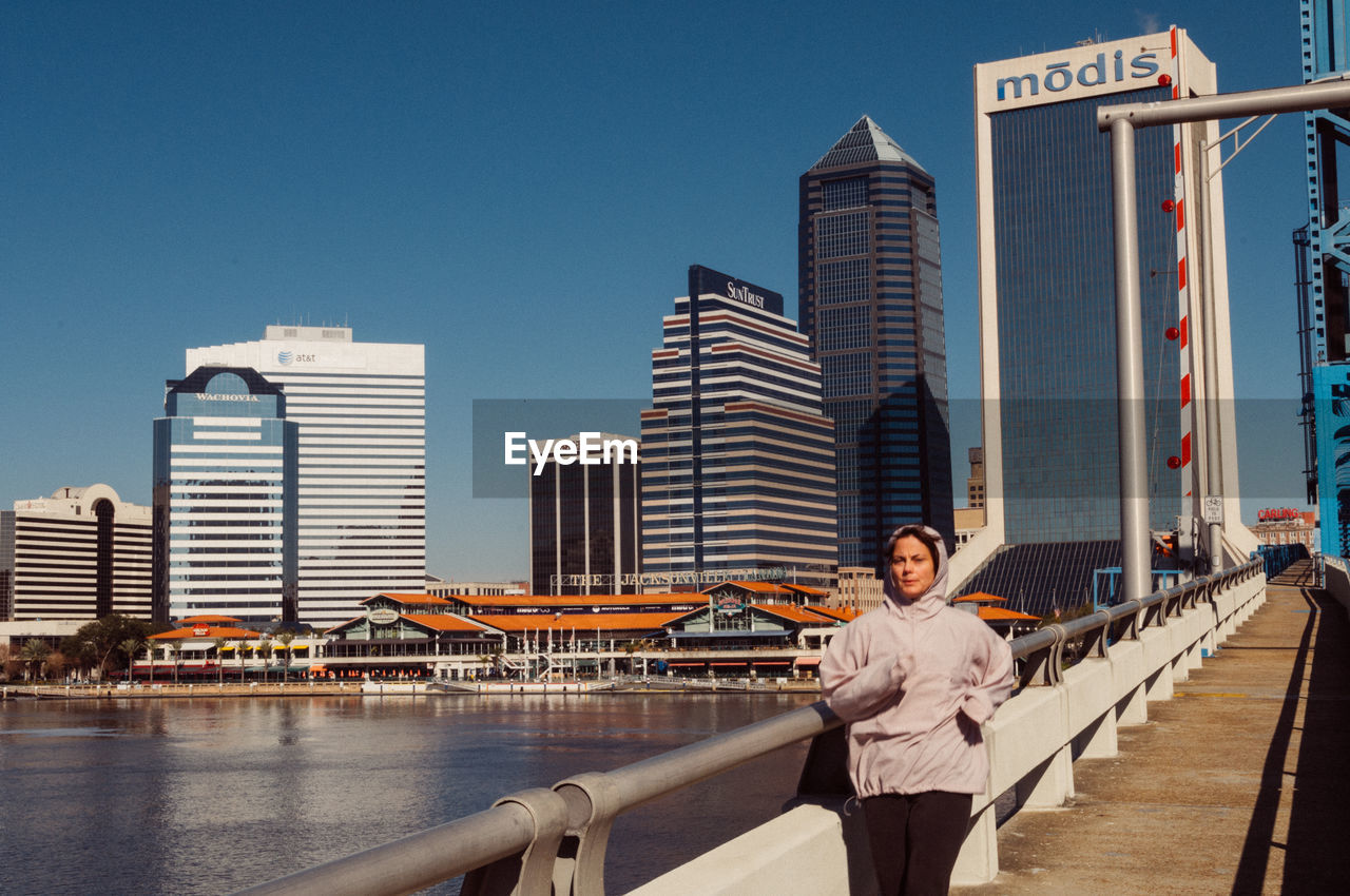 WOMAN STANDING IN CITY