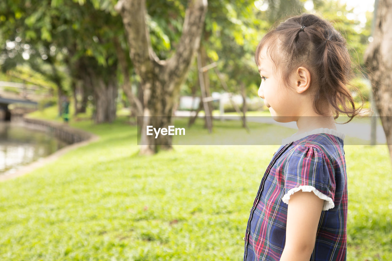 Side view of girl standing at park