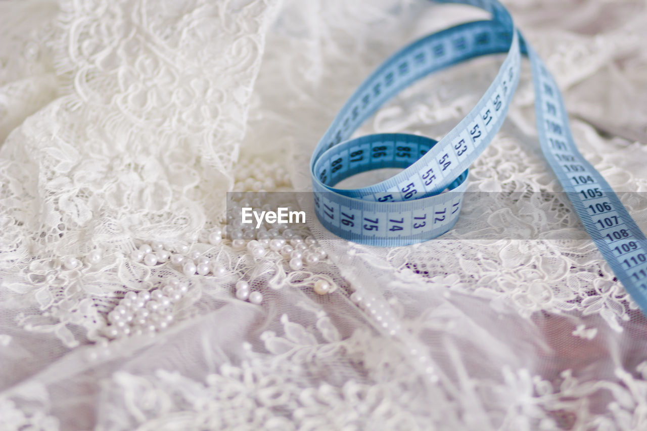 Close-up of tape measure on white dress