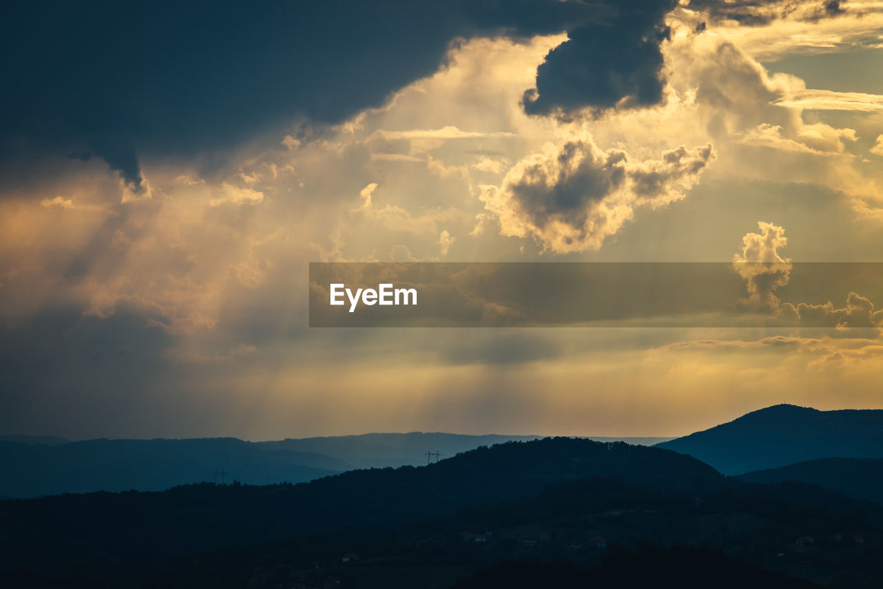 SCENIC VIEW OF DRAMATIC SKY OVER SILHOUETTE MOUNTAINS