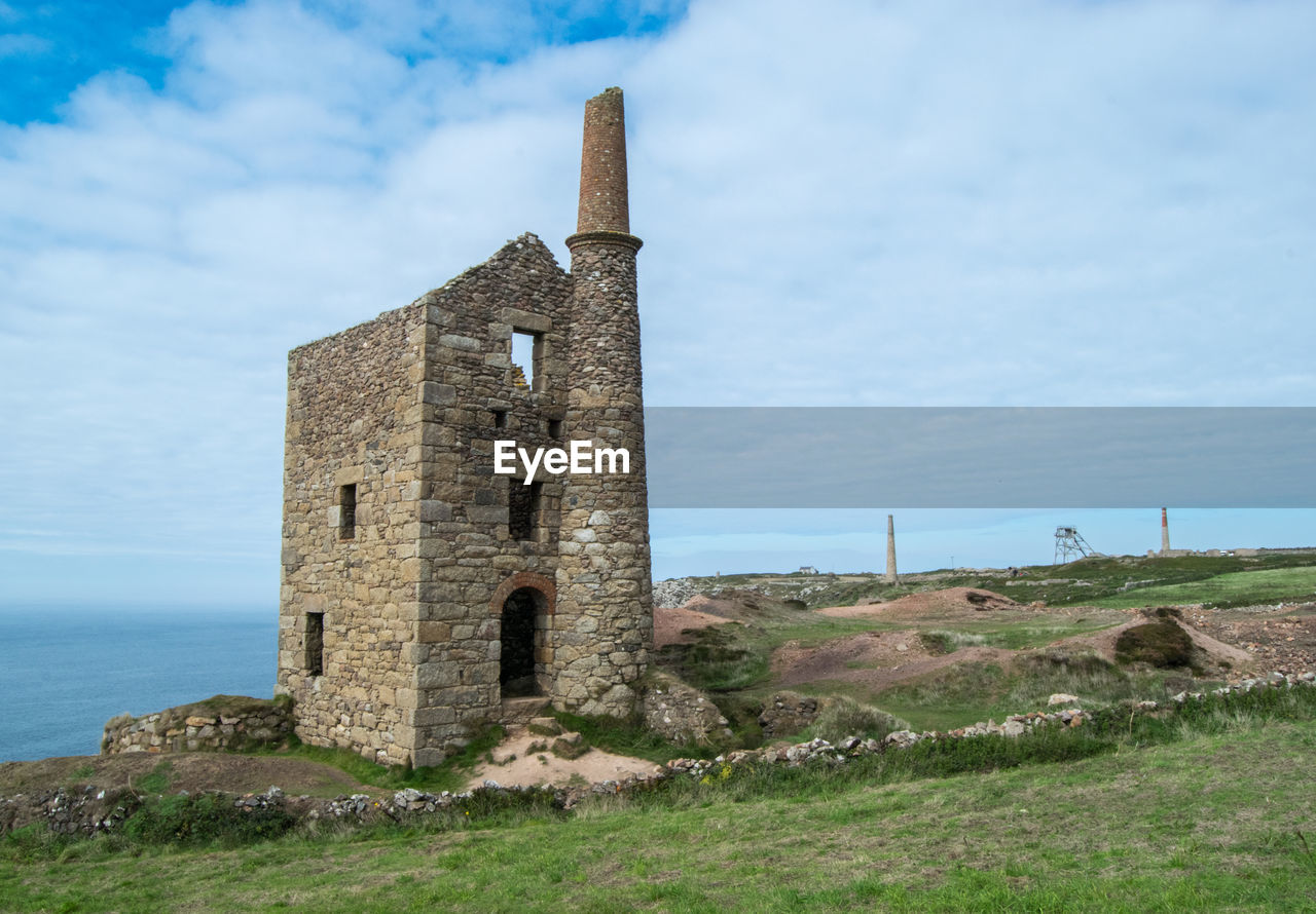 OLD RUIN BUILDING ON FIELD AGAINST SKY