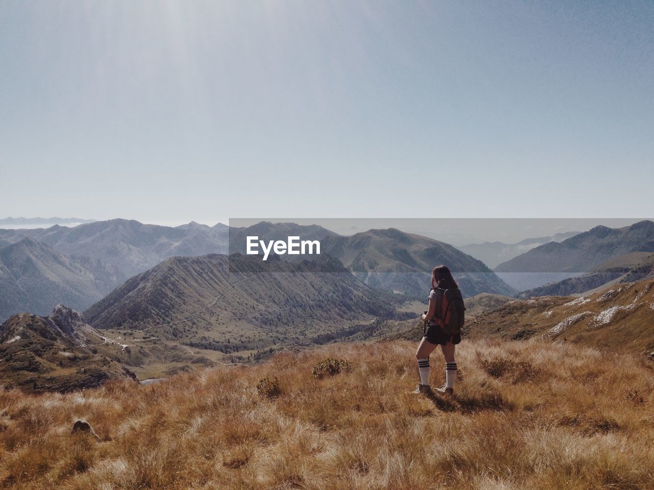 Full length of woman standing on mountain against sky