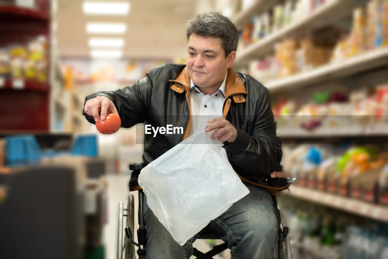 A disabled person in a wheelchair buys groceries