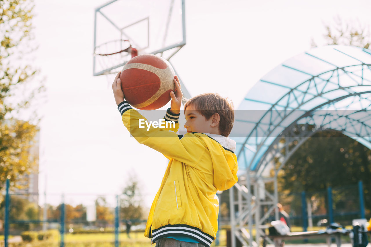 Boy playing with basketball in court