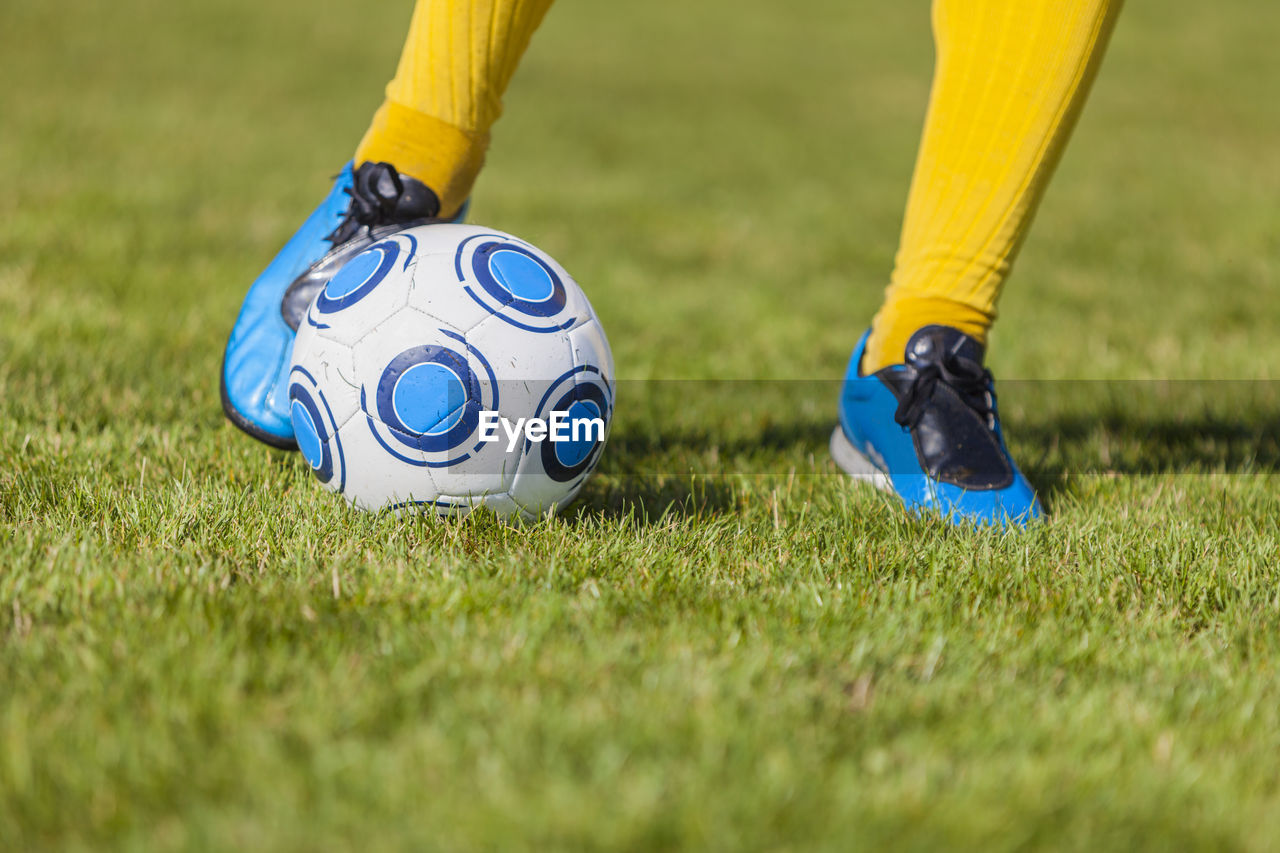 Low section of person playing soccer on field