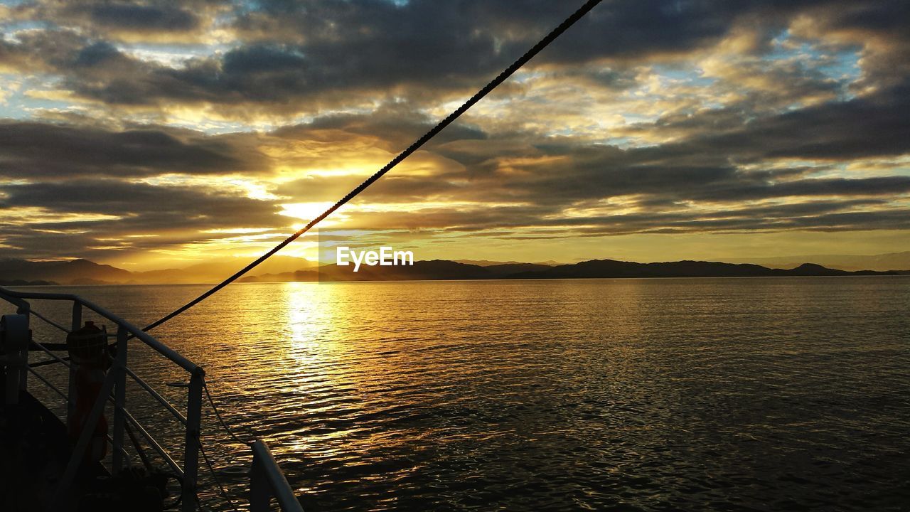 SILHOUETTE OF PERSON FISHING IN SEA