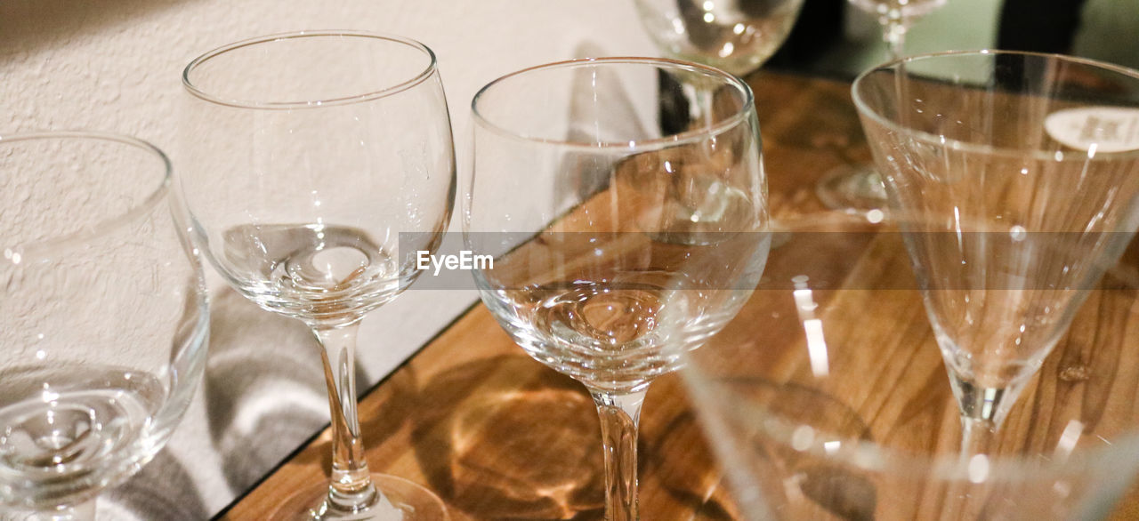 High angle view of drinking glasses on wooden table