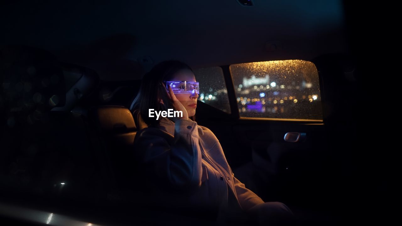 Fashion cyberpunk business woman wearing vr glasses and drive car