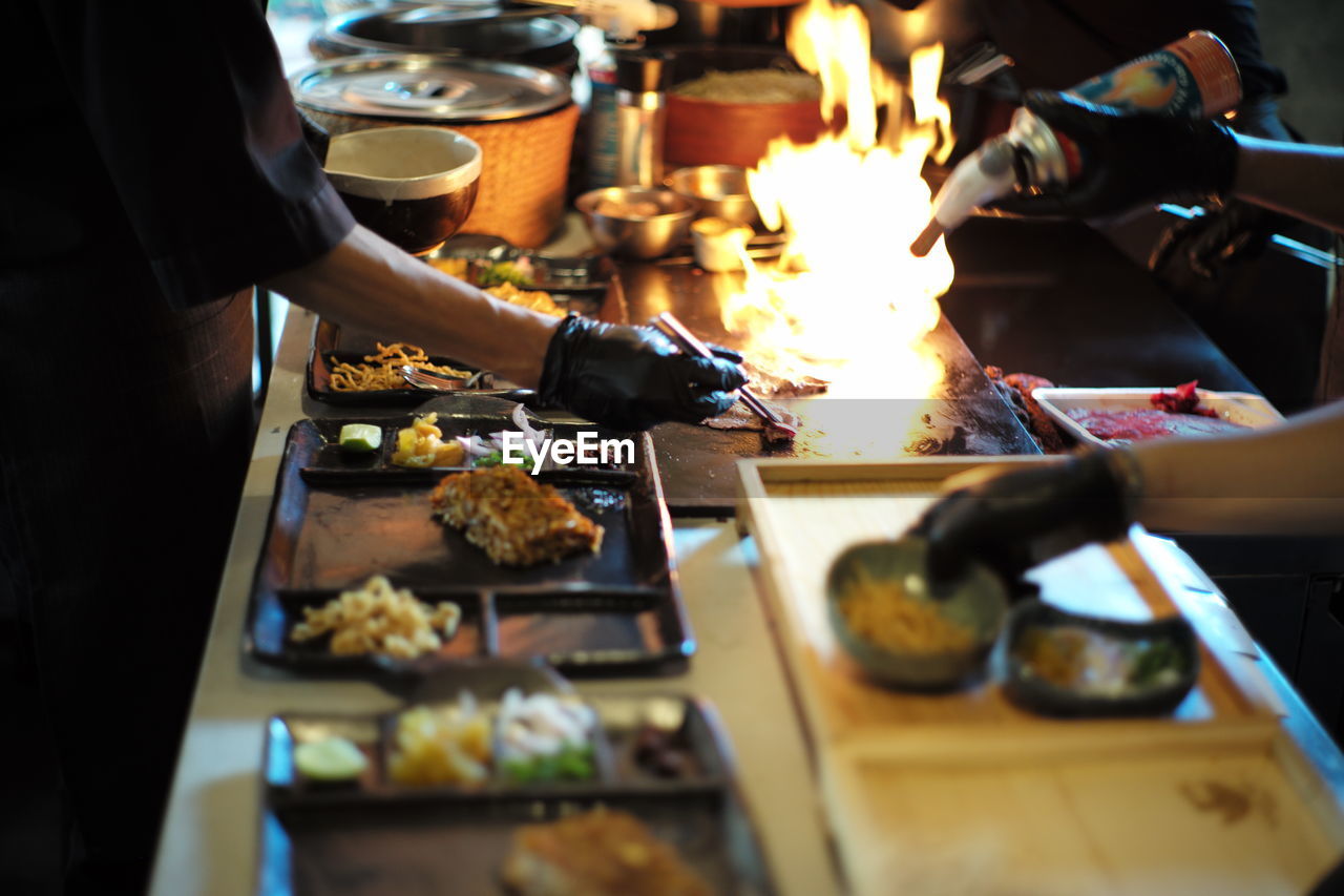 Midsection of man preparing food on barbecue grill