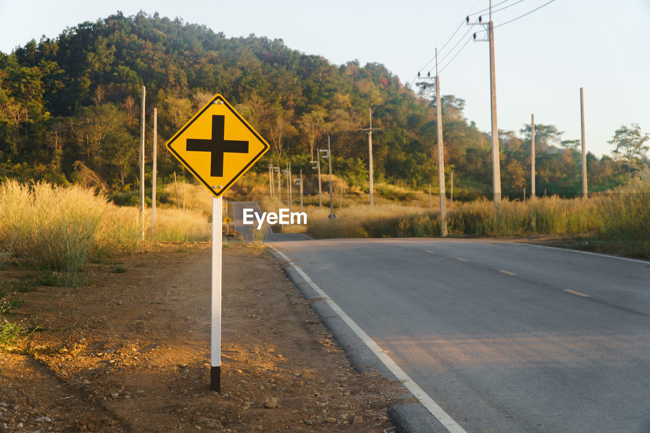 ROAD SIGN AGAINST TREES AND PLANTS