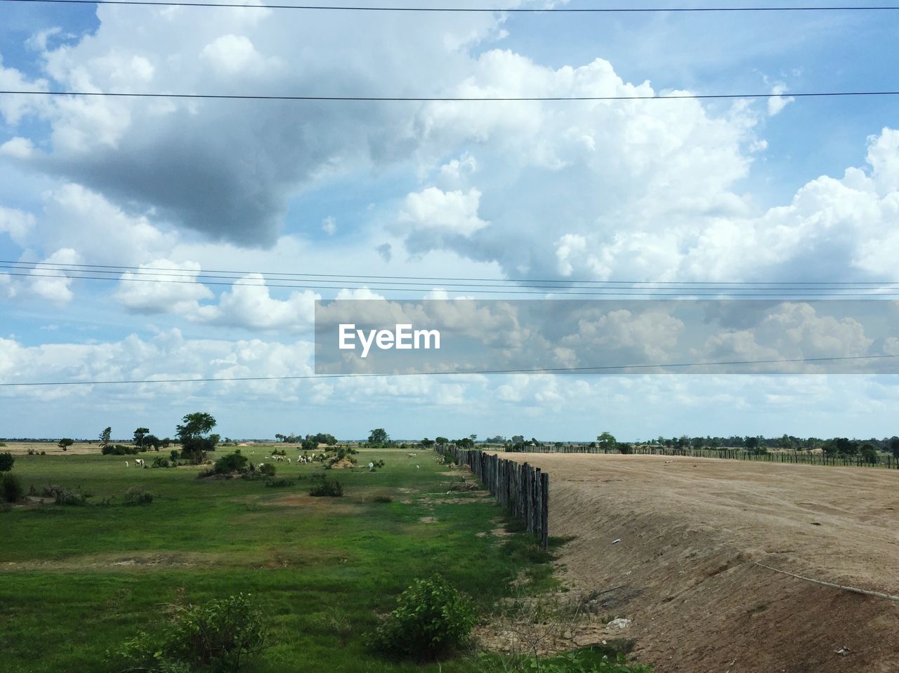 Scenic view of field against cloudy sky