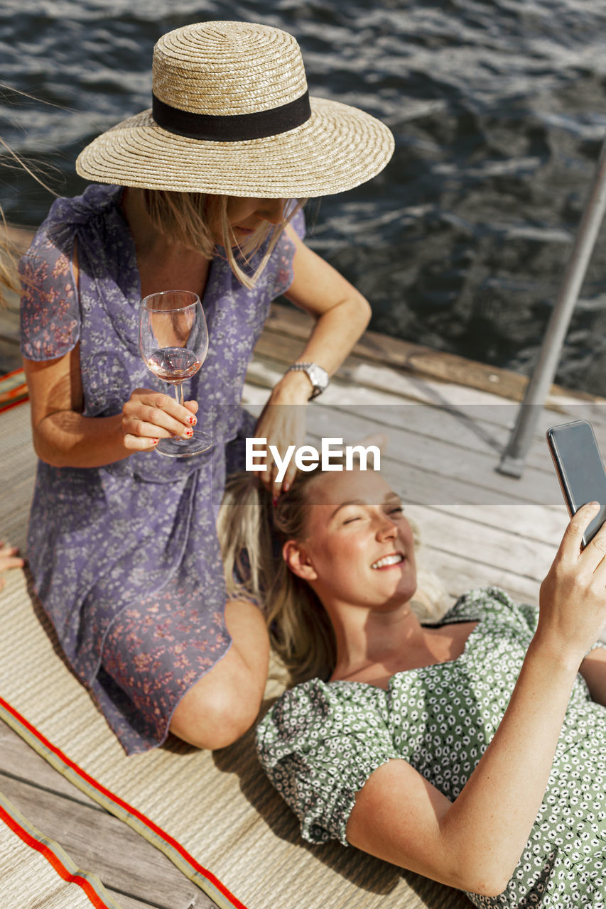 Female friends relaxing on jetty