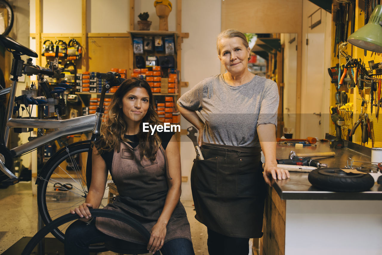 Portrait of smiling coworkers in bicycle shop