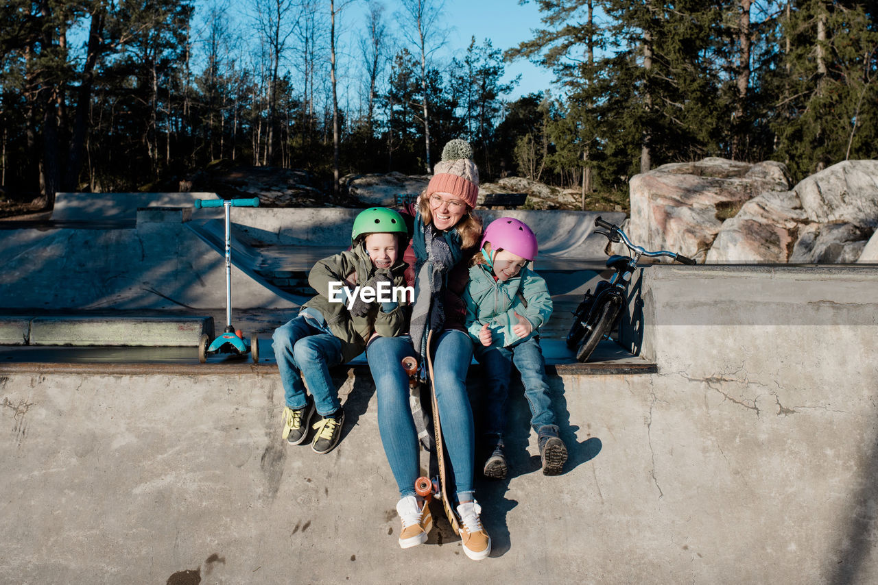 Mom playing with her kids at an outdoor skatepark having fun