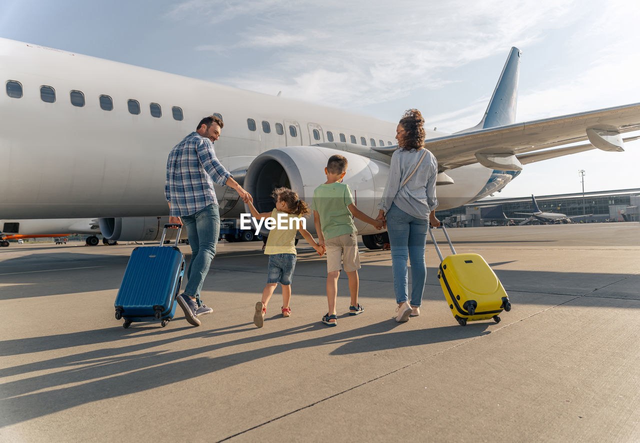 people on airport runway against sky