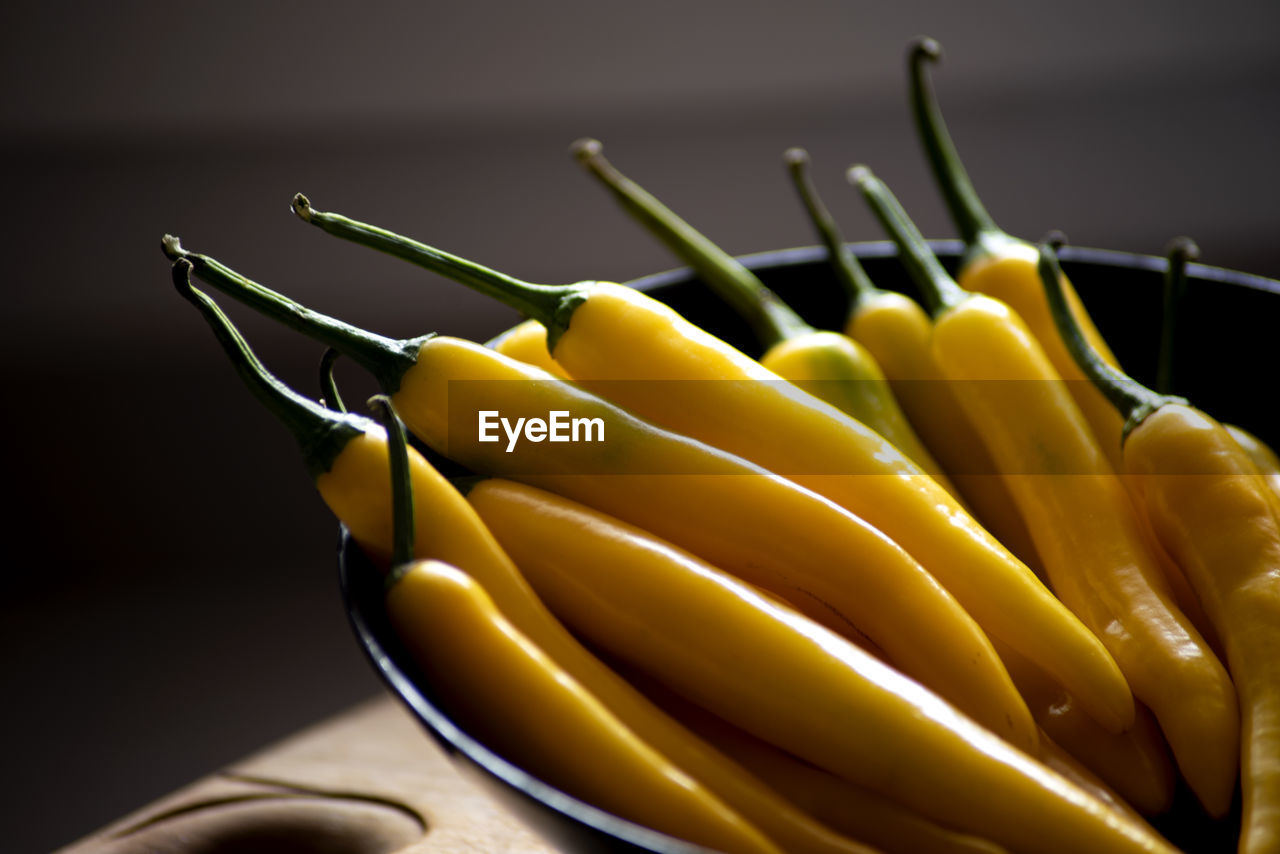 Yellow natural chilli pepper on a black kitchen plate