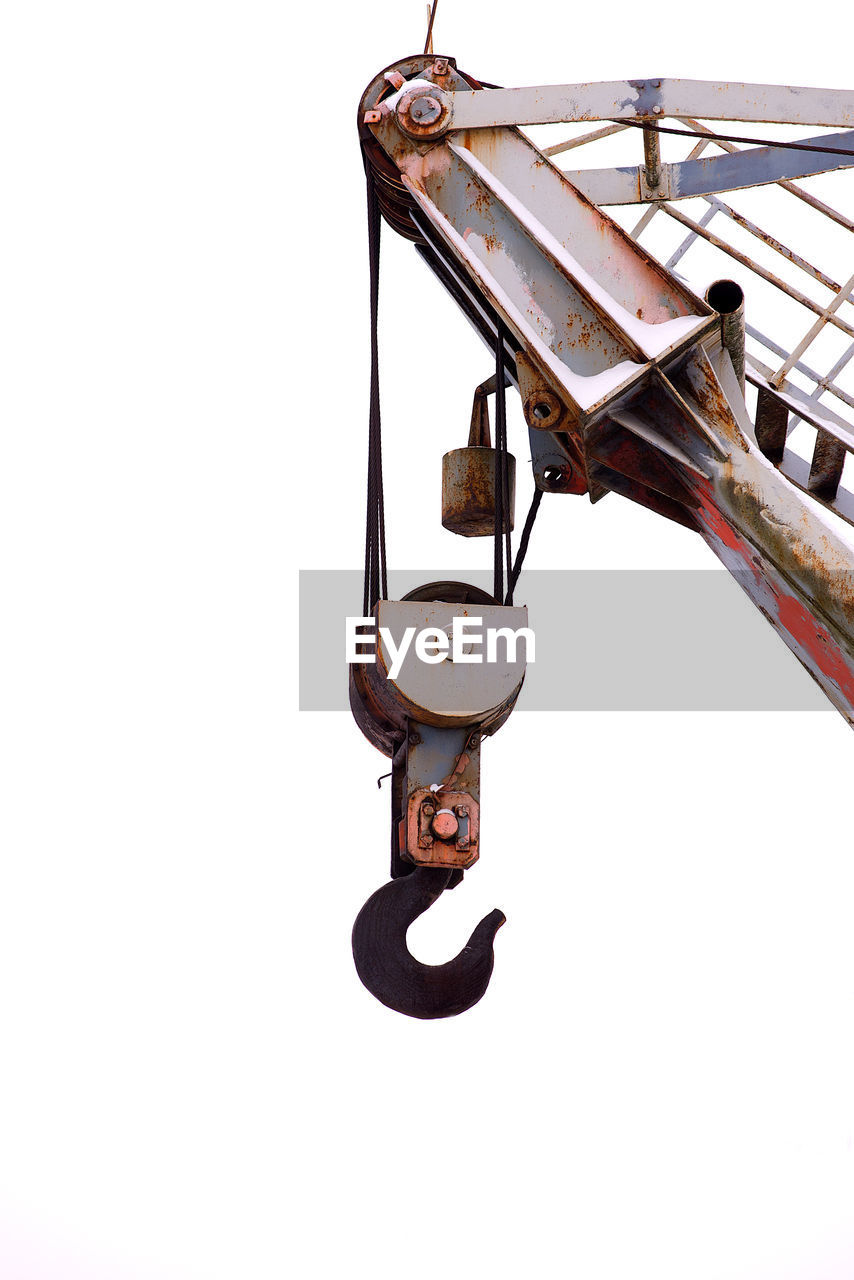 Low angle view of hook on crane against clear sky