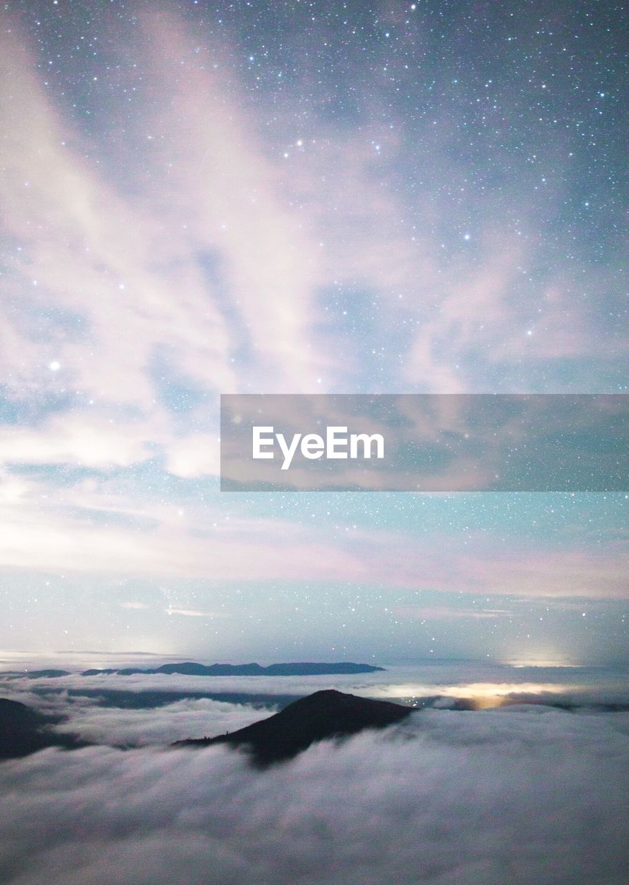 SCENIC VIEW OF SEA AGAINST CLOUDY SKY AT NIGHT