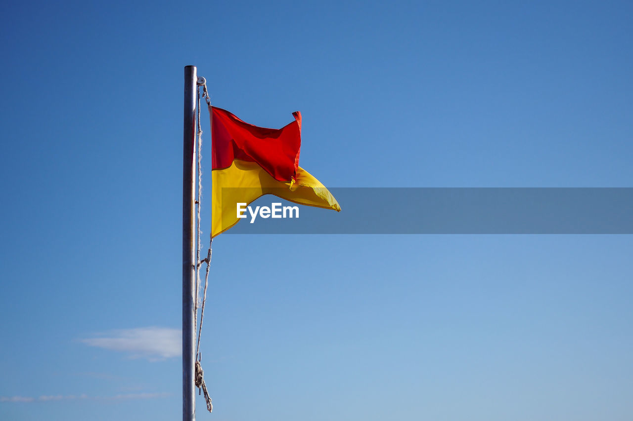 LOW ANGLE VIEW OF FLAG AGAINST CLEAR SKY