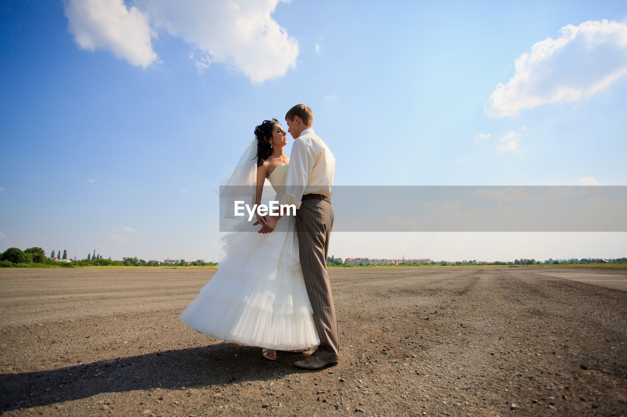 Couple kissing against sky