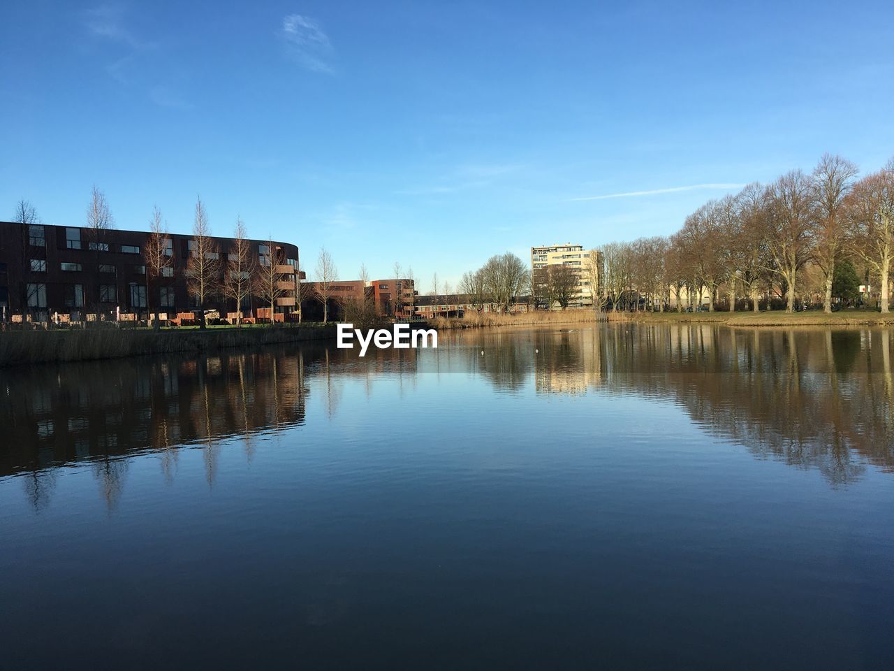 SCENIC VIEW OF LAKE BY BUILDINGS AGAINST SKY