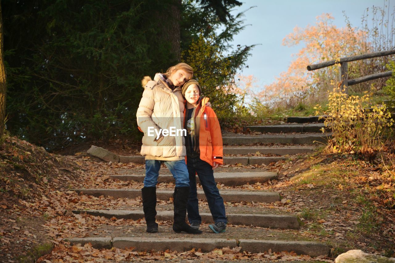 FULL LENGTH OF A YOUNG WOMAN STANDING ON STEPS