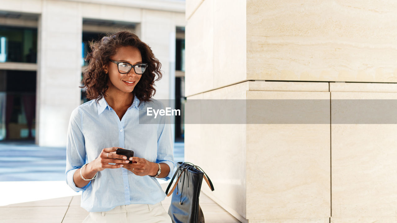 Smiling woman using mobile phone