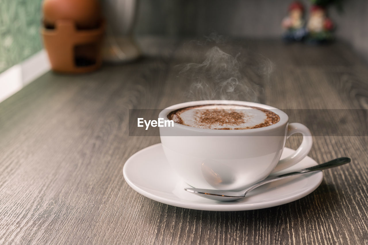 CLOSE-UP OF COFFEE CUP WITH TEA ON TABLE