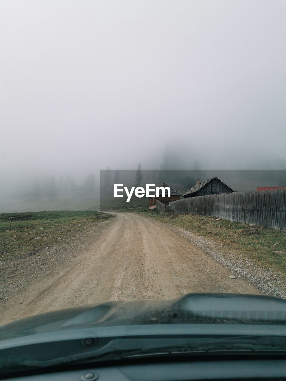 ROAD IN RAIN SEEN THROUGH CAR WINDSHIELD