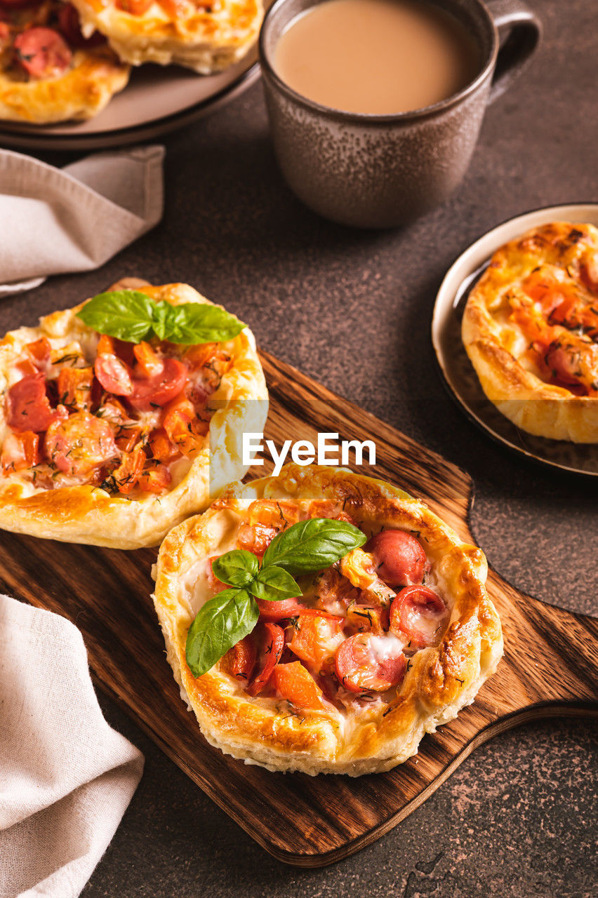 Chicago pizza pot pie with tomatoes, cheese and sausage on a wooden board vertical view