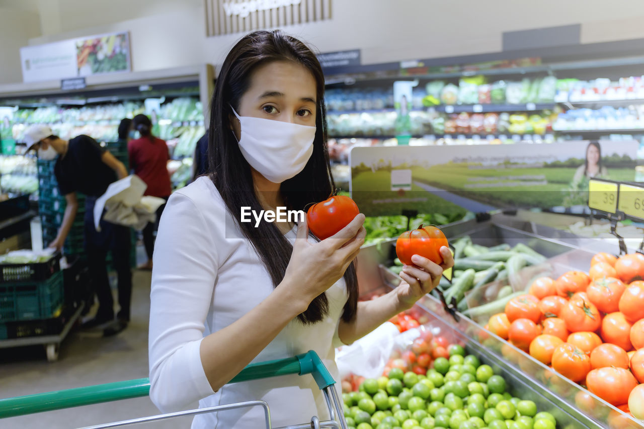 Portrait of woman buying vegetables at supermarket