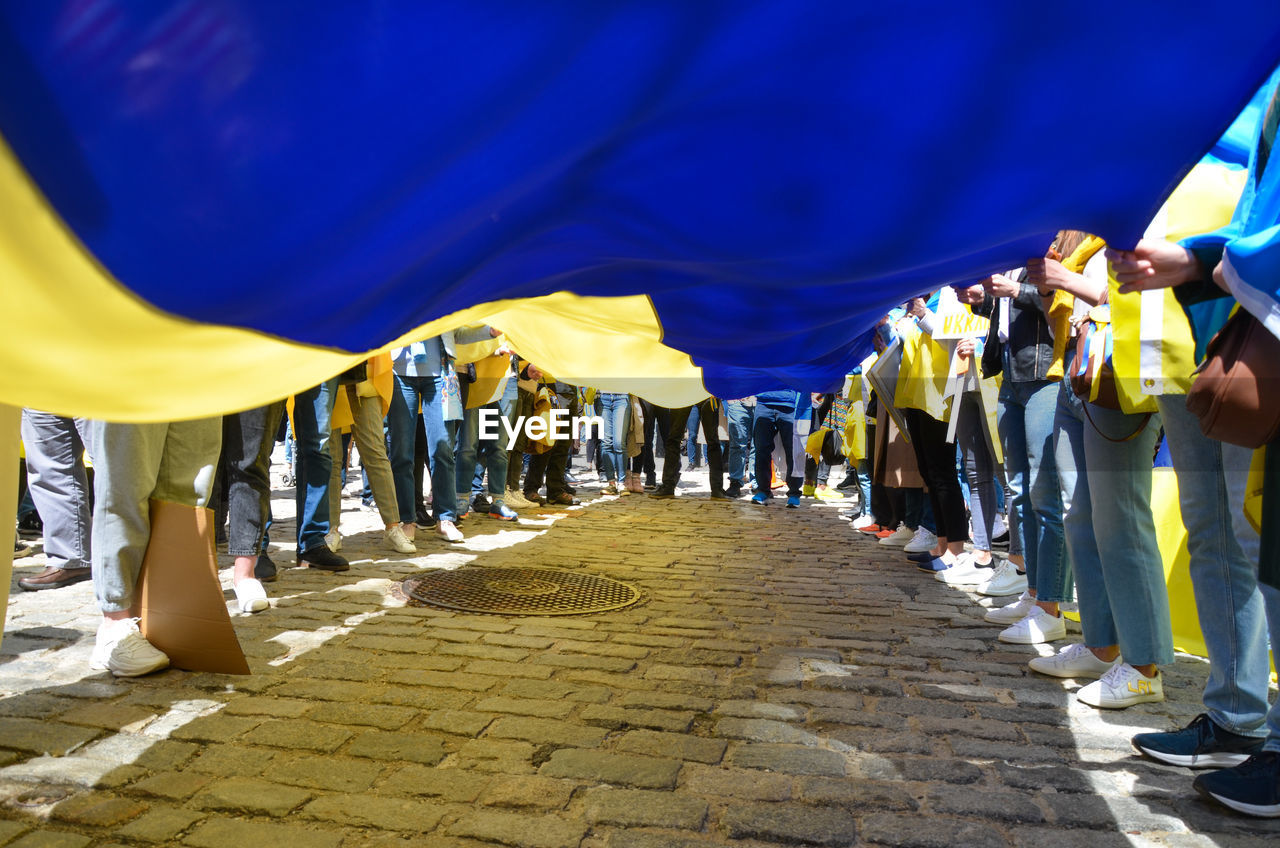 Demonstrators hold a giant ukrainian flag in new york city to stand in solidarity with ukraine.