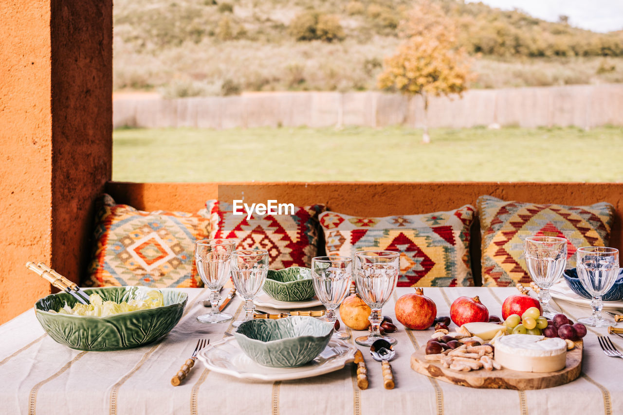 Table served with tableware and assorted ripe fruits and delicious appetizers on terrace