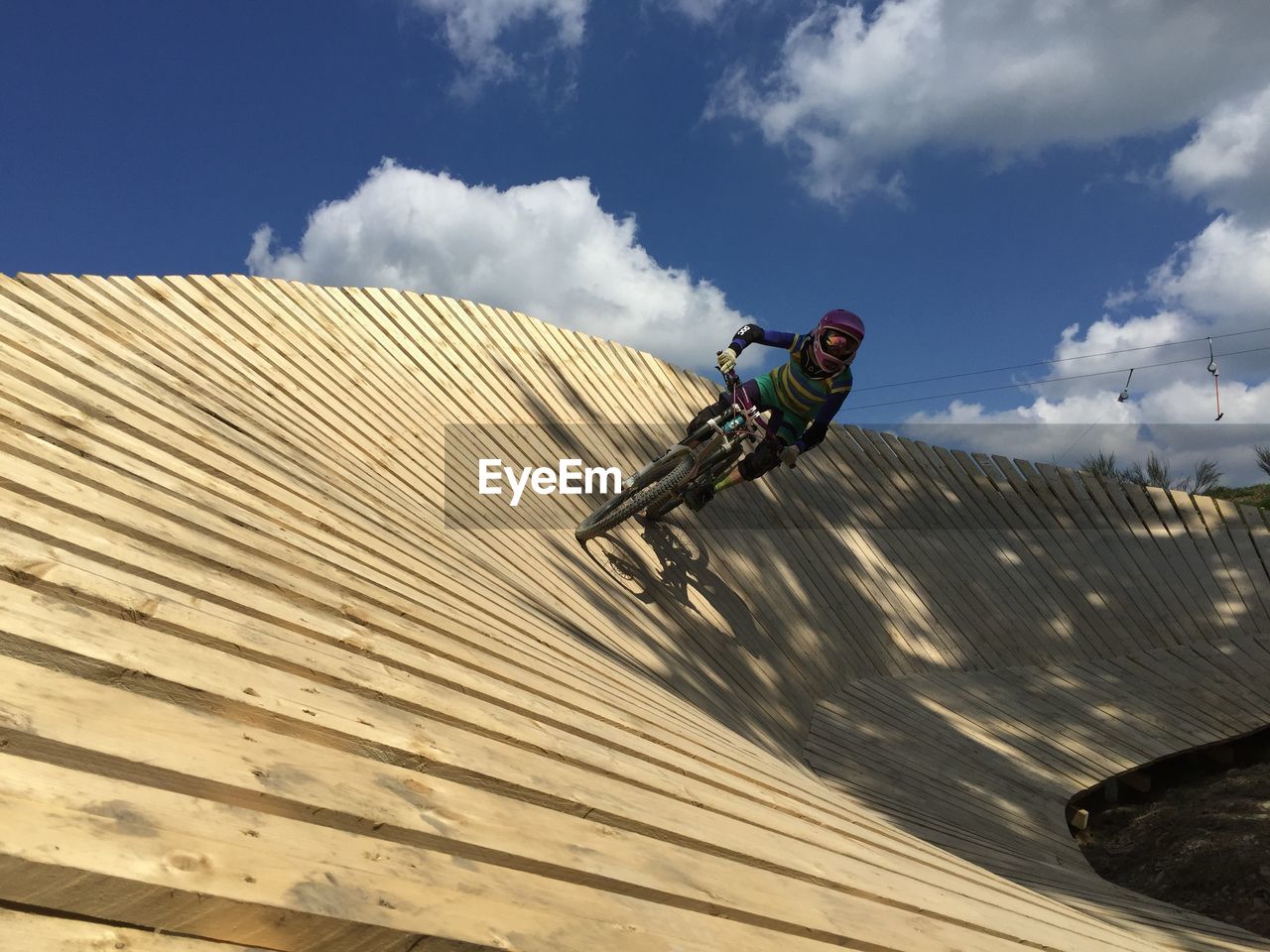 Low angle view of man riding mountainbike against sky