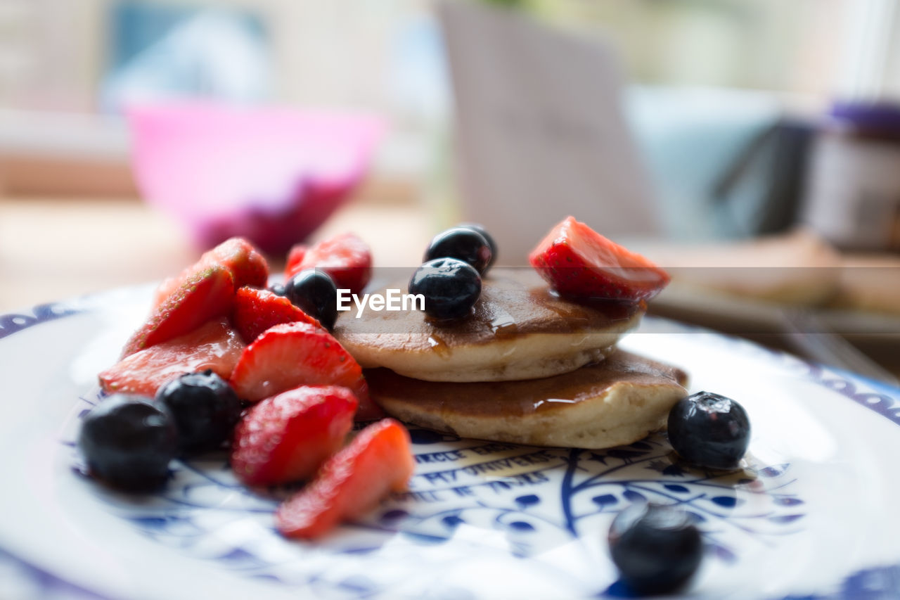 Close-up of fruits with pancakes in plate