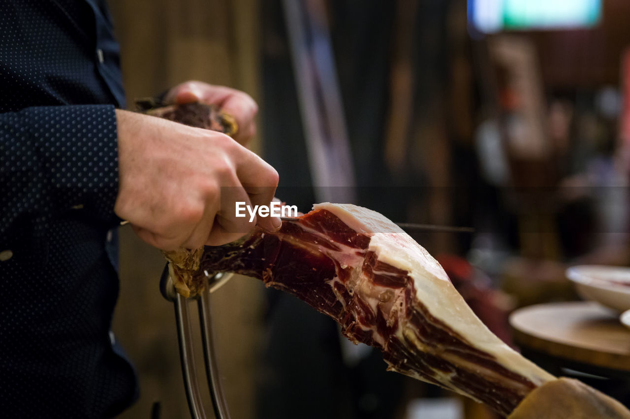 MIDSECTION OF MAN PREPARING FOOD IN KITCHEN