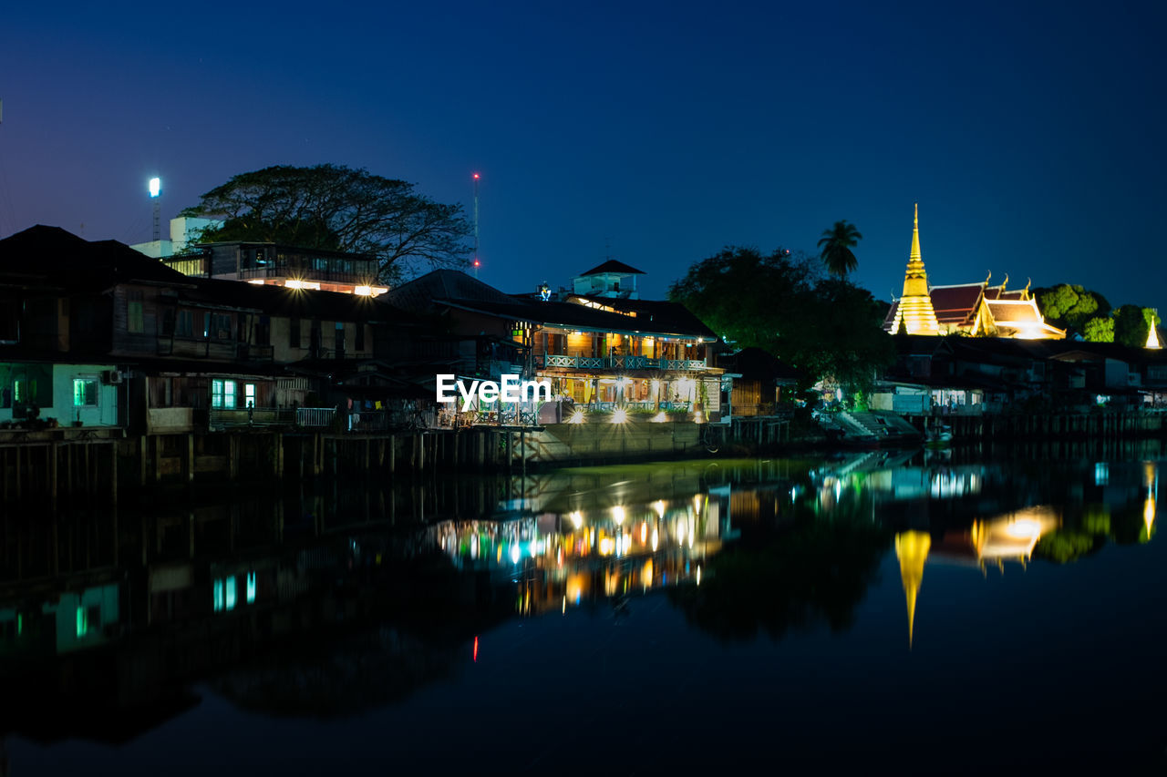 Reflection of buildings in lake at night