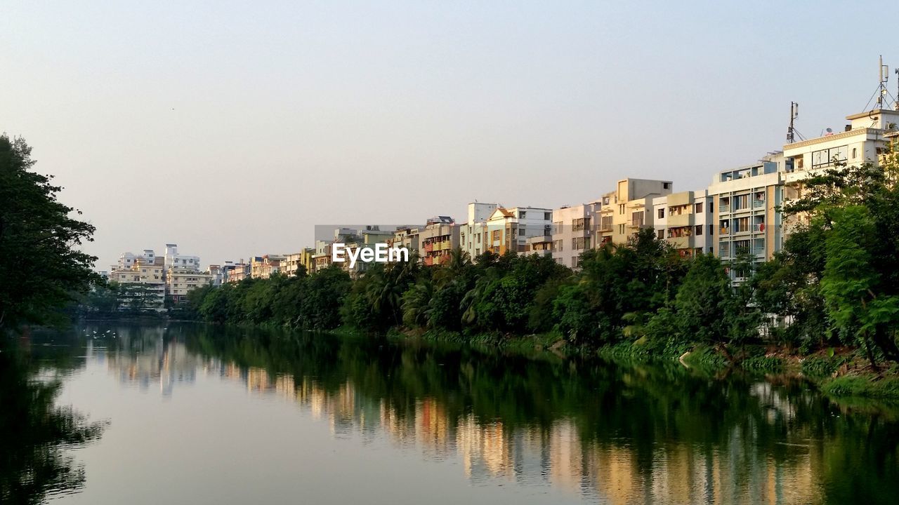 Scenic view of lake by buildings against clear sky