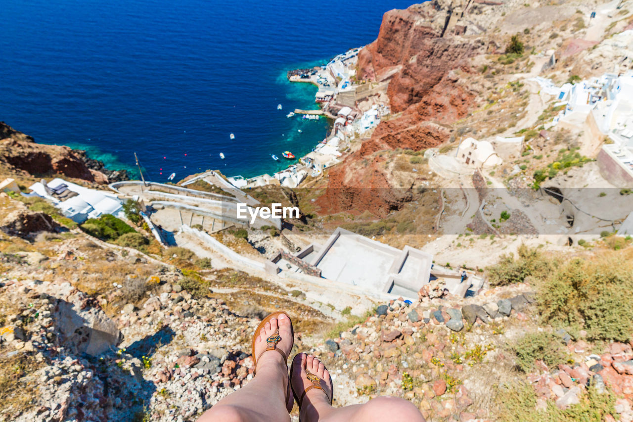 Low section of woman on cliff over sea