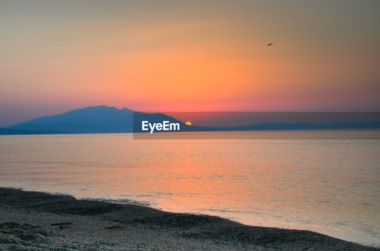 Scenic view of sea against orange sky