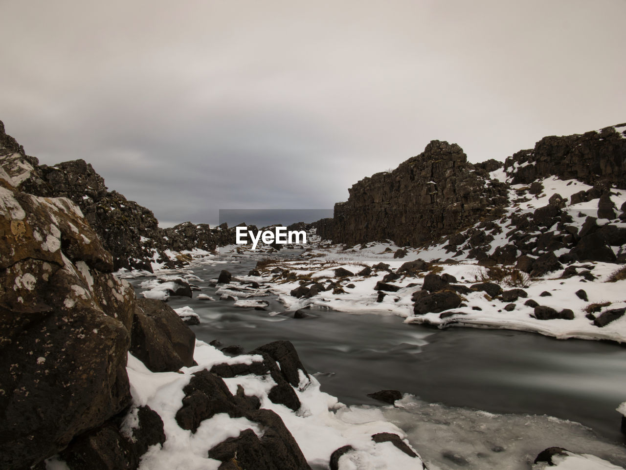 SNOW COVERED ROCKS AGAINST SKY