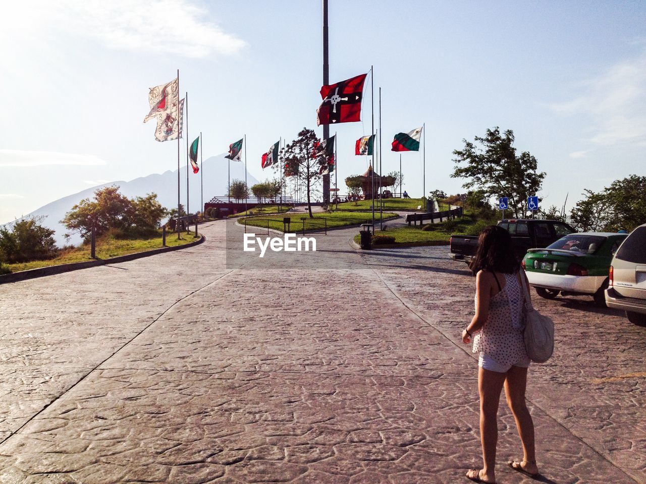 Rear view of woman standing in parking lot of tourist resort