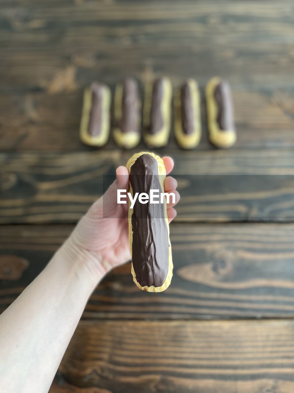 Hand holding a chocolate eclair