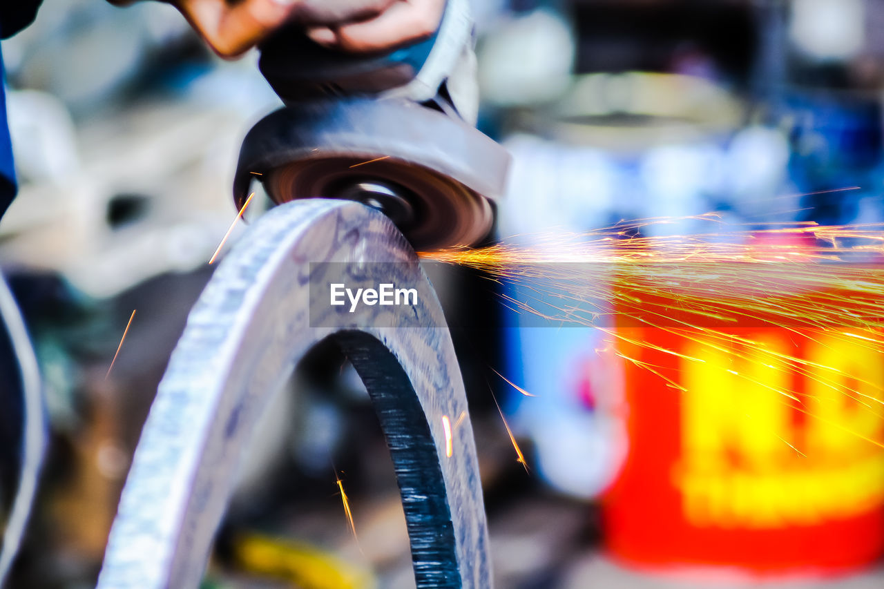 Close-up of person working on metal