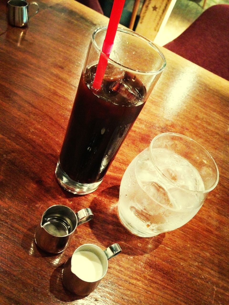 High angle view of iced coffee with water on table in cafe