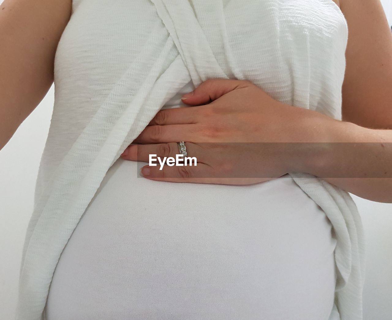 Midsection of pregnant woman wearing ring