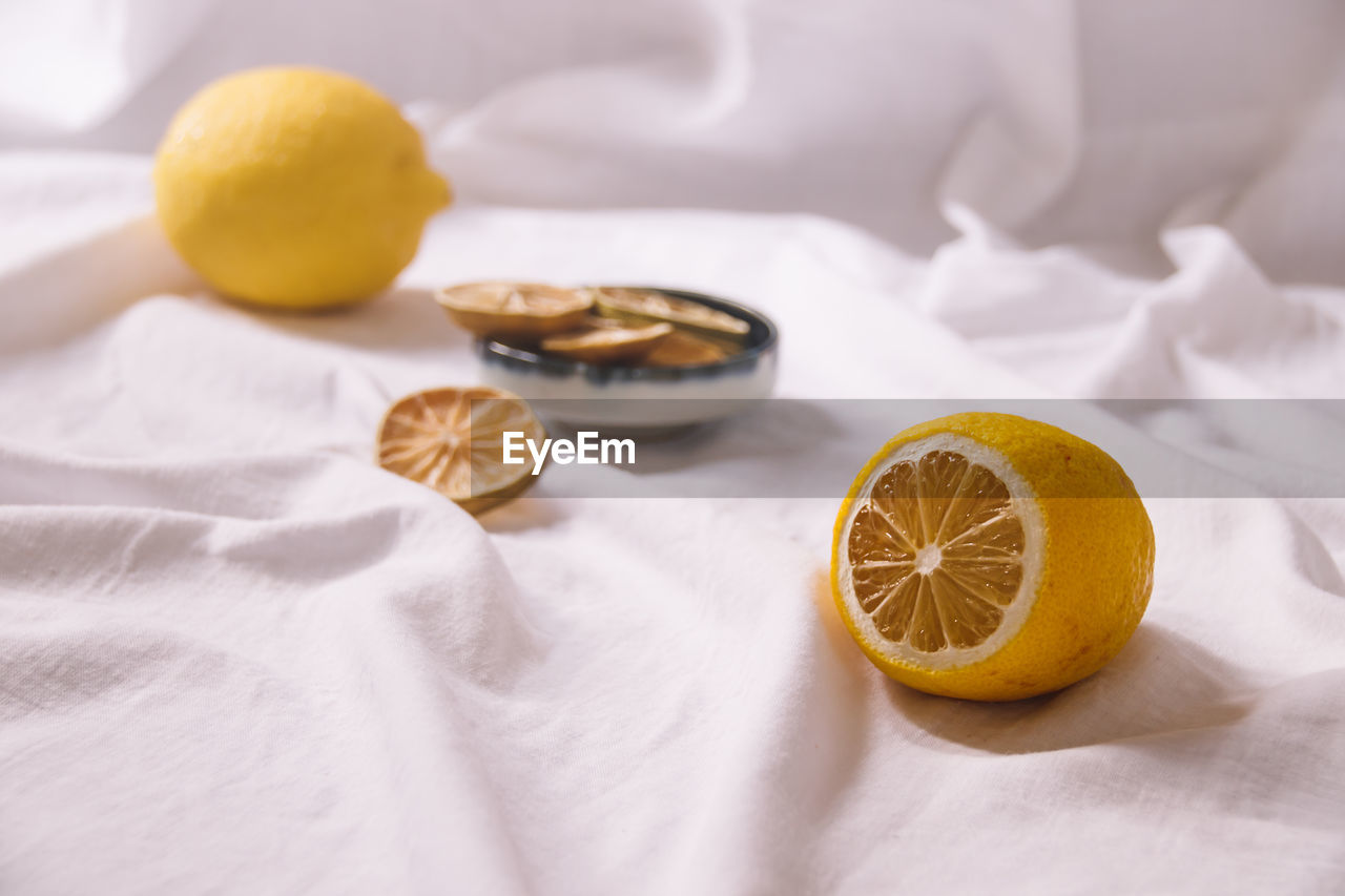lemon, food and drink, food, citrus fruit, fruit, healthy eating, citrus, orange, produce, wellbeing, yellow, plant, textile, indoors, freshness, citron, studio shot, no people, clementine, slice, bed, linen, vitamin, cross section, orange color, drink, still life